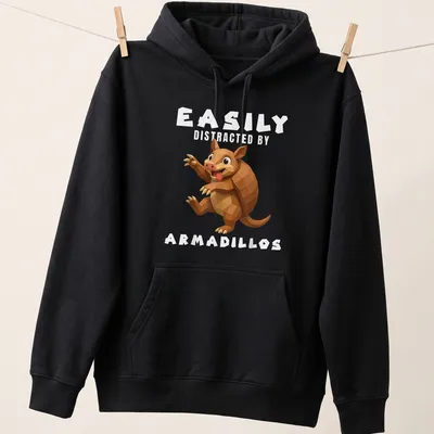 Low poly illustration of an armadillo with the text Easily Distracted By Armadillos — printed on a unisex hoodie