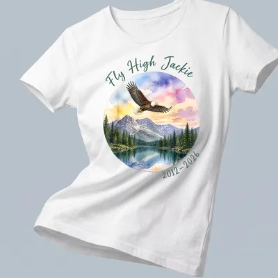 Watercolor print of a bald eagle with Fly High Jackie tribute text in colorful lettering — printed on a women's shirt