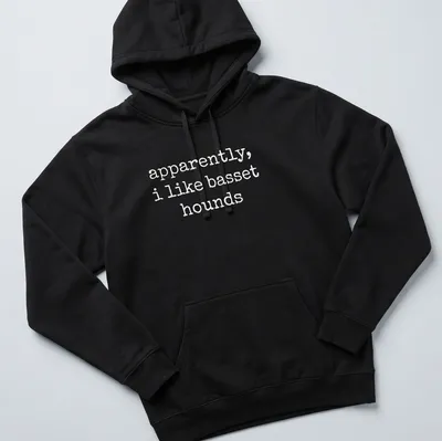 Simple text graphic stating apparently, i like basset hounds on a white — printed on a unisex hoodie