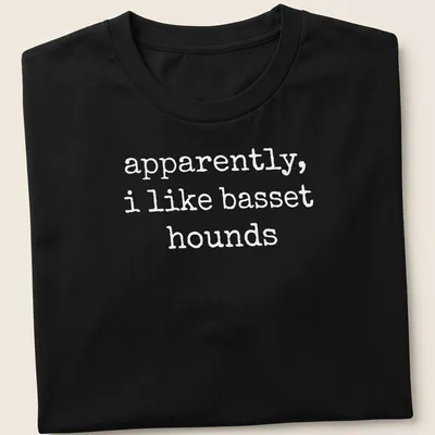 Simple text graphic stating apparently, i like basset hounds on a white t-shirt