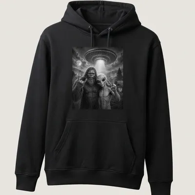 Bigfoot and alien share a selfie with a peace sign in black and white typography — printed on a unisex hoodie