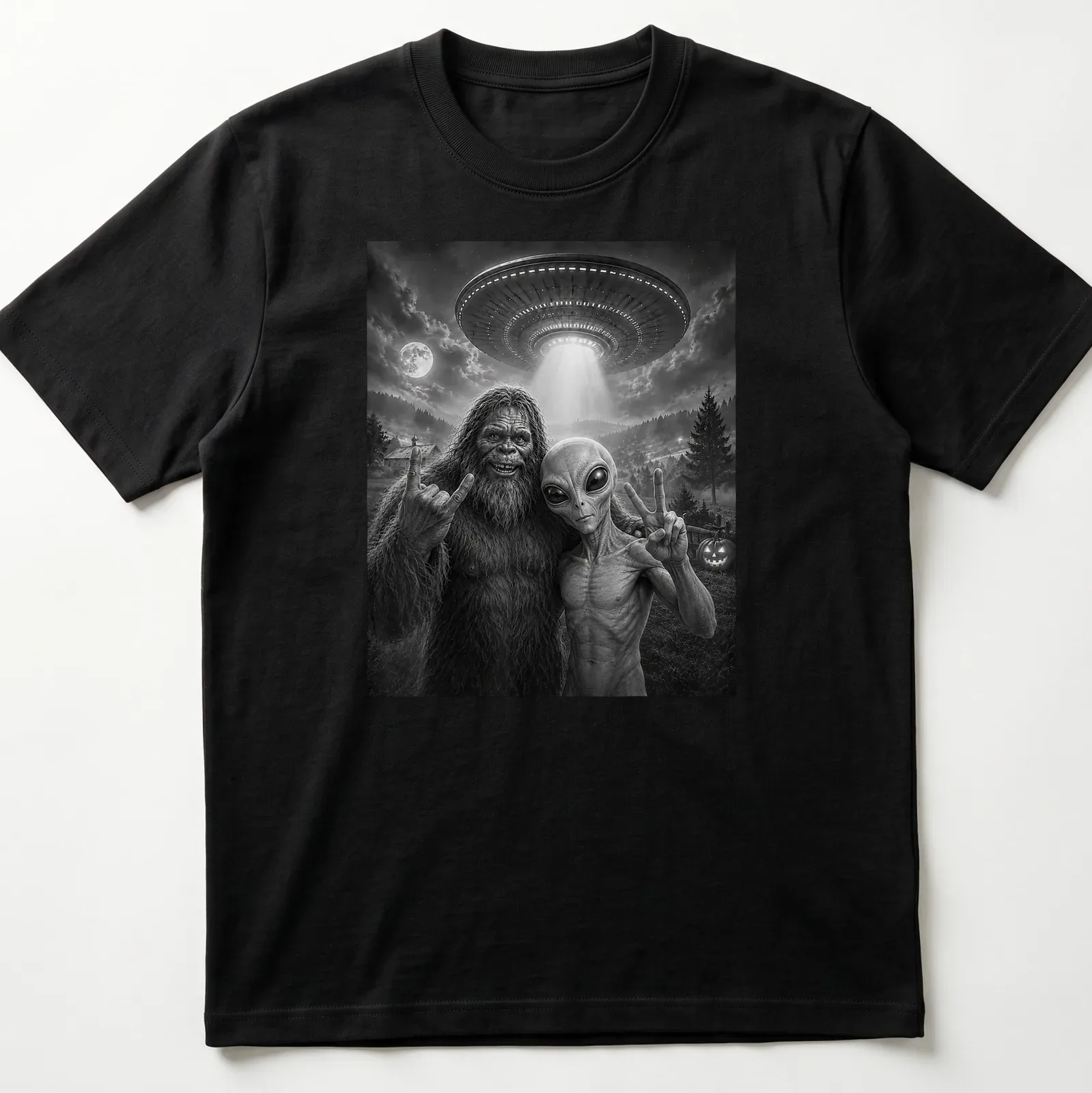 Bigfoot and alien share a selfie with a peace sign in black and white typography — printed on a unisex t-shirt