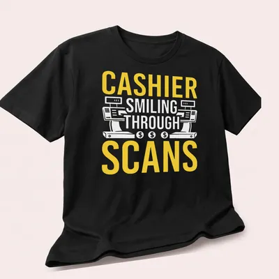 Bold typography T-shirt with the text 'CASHIER SMILING THROUGH SCANS' in yellow and white — printed on a unisex t-shirt (angled view)