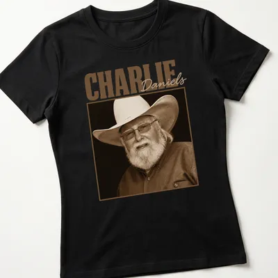 Sepia portrait of Charlie Daniels with text below in classic font — printed on a women's shirt