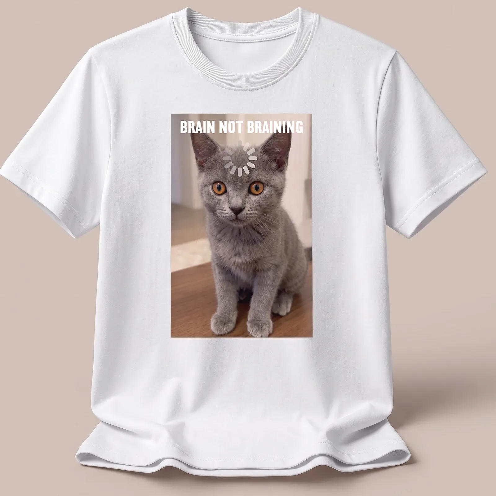 Realistic print of a Chartreux kitten with the text 'BRAIN NOT BRAINING' in gray, orange, and white. — printed on a unisex t-shirt