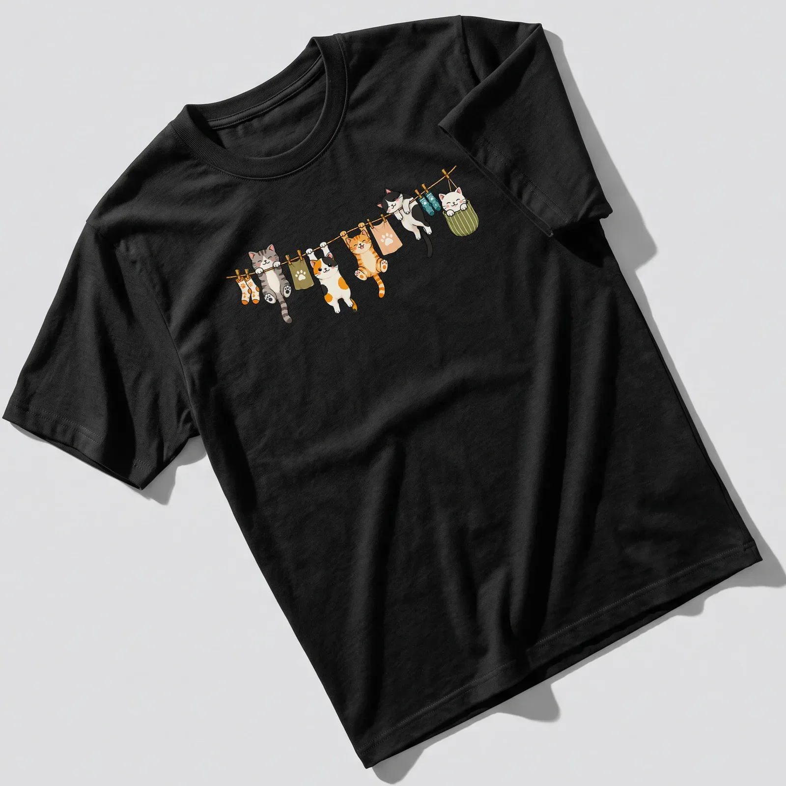 Kawaii print of cute cats hanging in playful poses in various colors — printed on a unisex t-shirt