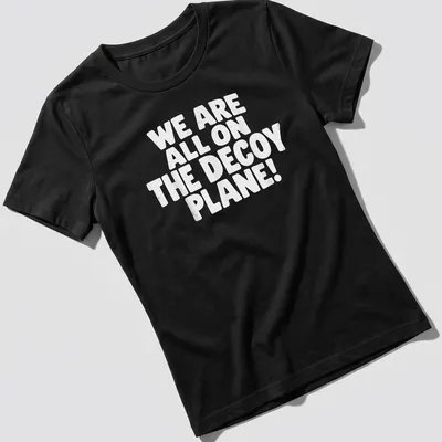 Bold typography shirt saying 'WE ARE ALL ON THE DECoy PLANE!' in white — printed on a women's shirt