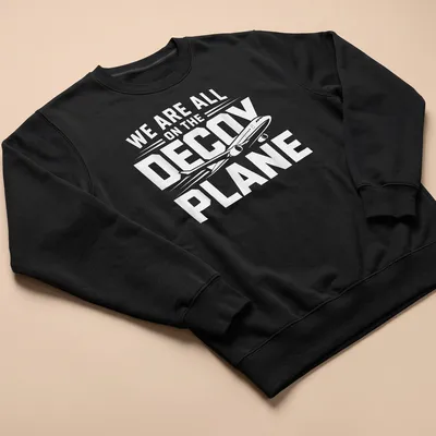 Bold typography shirt with the phrase We Are All On The Decoy Plane in white and black — printed on a unisex sweatshirt