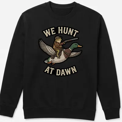 Cartoon frog riding a duck with the text 'We Hunt At Dawn' in vibrant colors — printed on a unisex sweatshirt