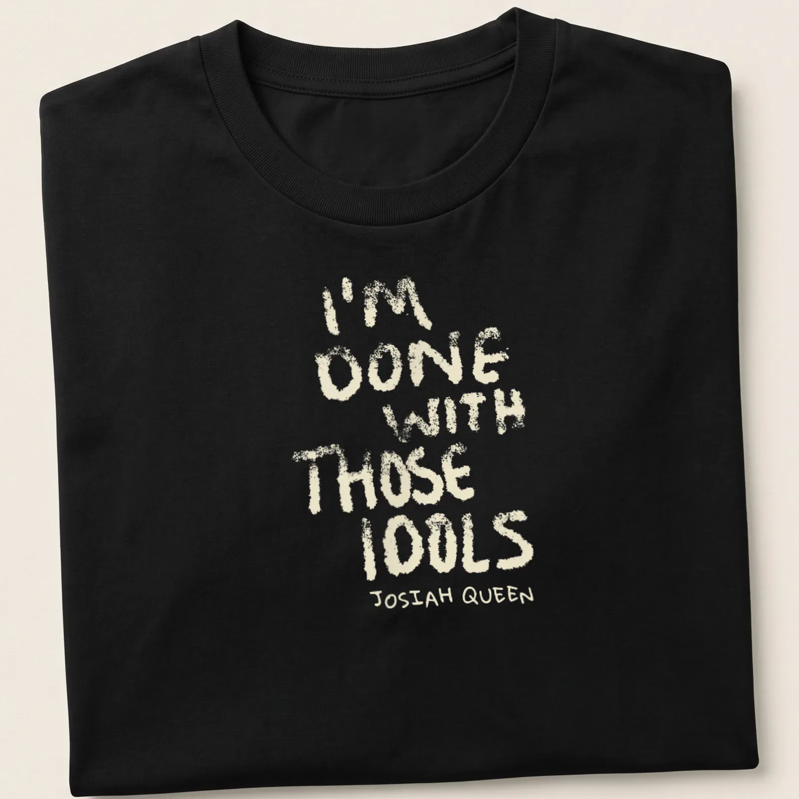 Text-based design featuring dusty bibles with the quote 'I'm Done With Those Idols Josiah Queen' — printed on a unisex t-shirt