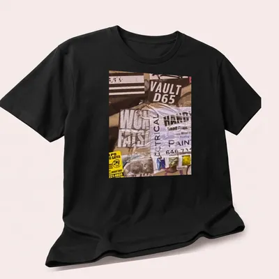 Graffiti-inspired t-shirt with bold text and urban collage design in black, white, yellow, and gray — printed on a unisex t-shirt (angled view)