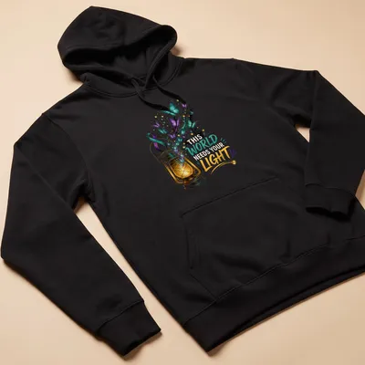 Colorful illustration of a lantern with butterflies and the text 'This World Needs Your Light' — printed on a unisex hoodie