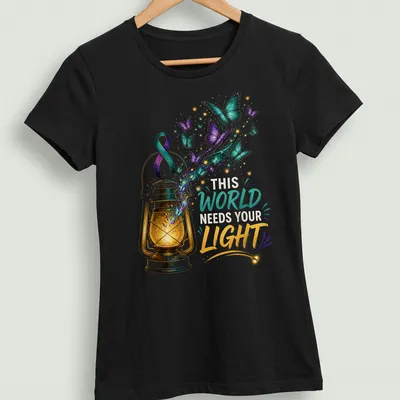 Colorful illustration of a lantern with butterflies and the text 'This World Needs Your Light' — printed on a women's shirt