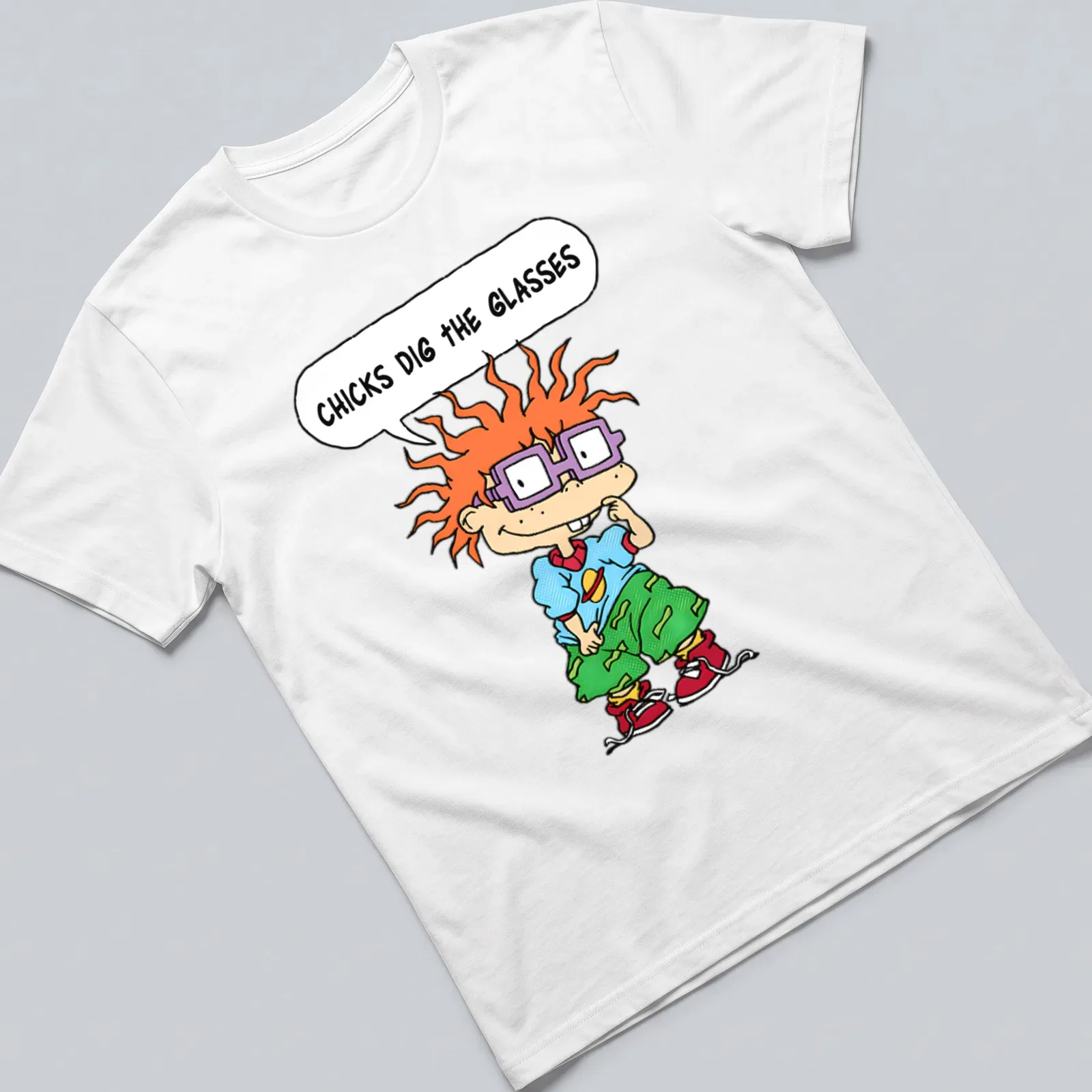 Cartoon boy with orange hair and purple glasses, text reads 'CHICKS DIG THE GLASSES' — printed on a unisex t-shirt