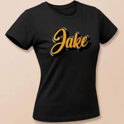 Bold cursive print of the name Jake in gold on a black — printed on a women's shirt