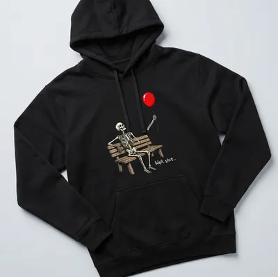 Cartoon skeleton on a bench holding a red balloon with humorous text saying 'Well, shit...' — printed on a unisex hoodie
