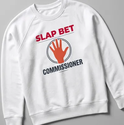 Bold graphic of hand slapping with text Slap Bet Commissioner in red, black, orange and white — printed on a unisex sweatshirt