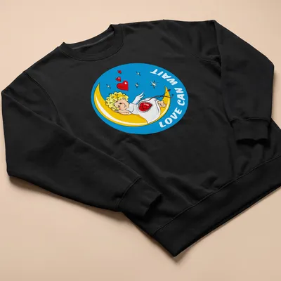 Cartoon of a sleeping Cupid on the moon with text Love Can Wait. — printed on a unisex sweatshirt