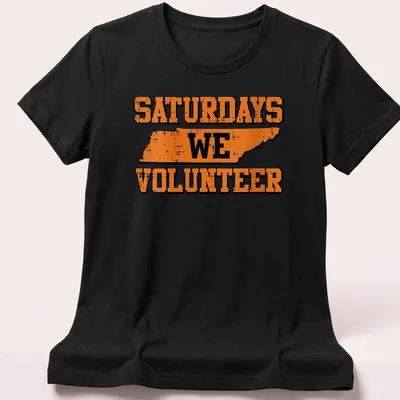Distressed Tennessee outline with the text Saturdays We Volunteer in orange and black. — printed on a women's shirt