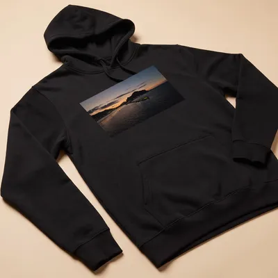 Photographic print of a tranquil harbor at sunset with golden and blue hues — printed on a unisex hoodie