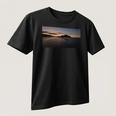 Photographic print of a tranquil harbor at sunset with golden and blue hues — printed on a unisex t-shirt (angled view)
