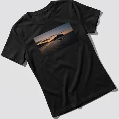 Photographic print of a tranquil harbor at sunset with golden and blue hues — printed on a women's shirt