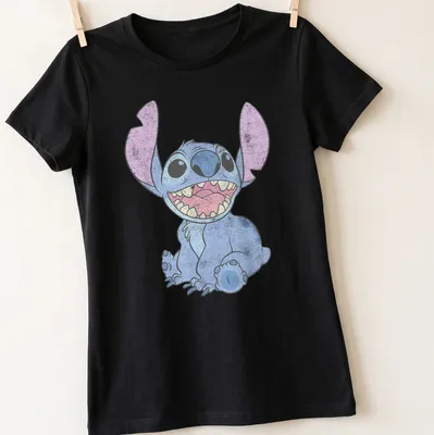 Cartoon of a happy alien character in bright colors against a tropical background — printed on a women's shirt