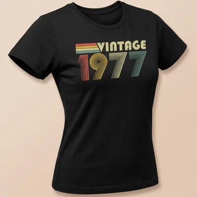 Distressed T-shirt with 'VINTAGE 1977' text in red, green, yellow, and cream colors — printed on a women's shirt