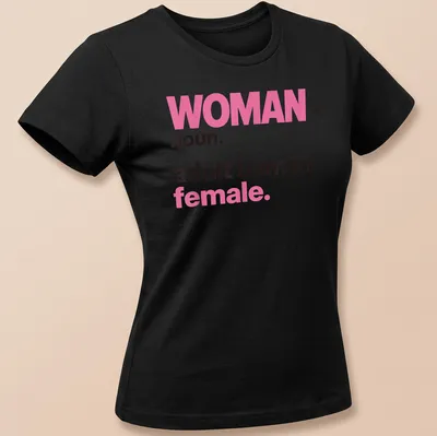 Bold typography t-shirt declaring 'WOMAN noun. adult human female.' in pink and black — printed on a women's shirt